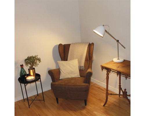 Mysig läshörna med fåtölj, bordslampa och sidobord