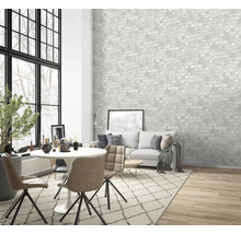 Vardagsrum med matbord, stolar, soffa och mönstrad tapet med tegelmotiv