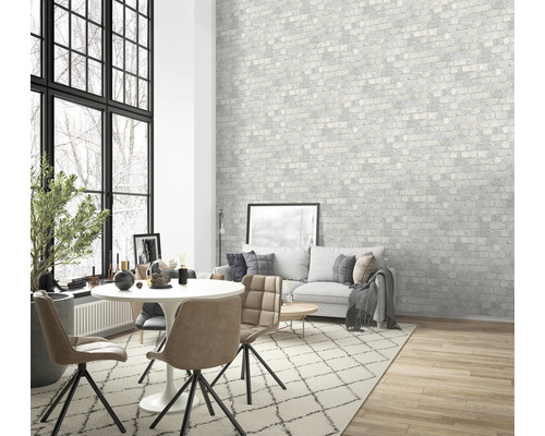 Vardagsrum med matbord, stolar, soffa och mönstrad tapet med tegelmotiv