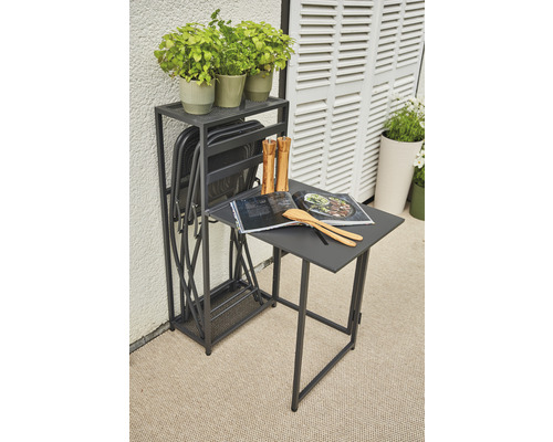 Trädgårdsscen med fällbord, fällstolar, örtkrukor, kokbok och köksredskap