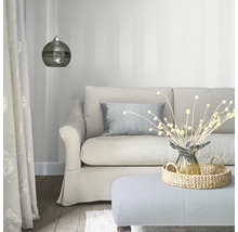 Vardagsrum med soffa, kuddar, lampa och dekorationsartiklar