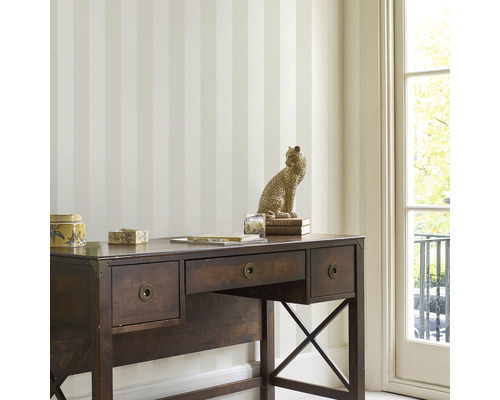 Scen med randig tapet och skrivbord i rummet.