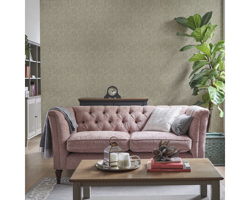 Vardagsrum med mönstrad tapet, soffa, soffbord och dekorationer