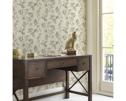 Dekorativt arbetsrum med skrivbord, tapet med växtmotiv och leopardskulptur.