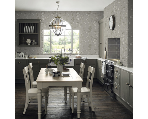 Ljust kök med matbord, stolar, väggskåp och tapet med blommönster