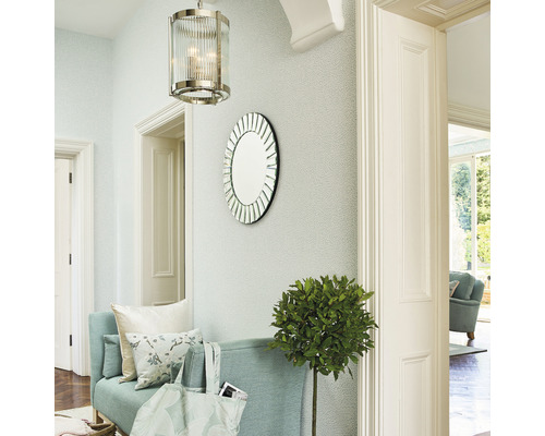 Entré med en bänk, en rund spegel, en hängande lampa och en krukväxt