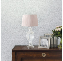 Dekorativ tapet med bladmönster, kombinerat med en lampa, fotoram, böcker och en blombukett på ett bord