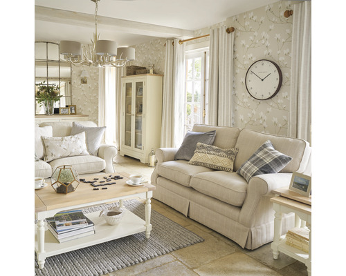 Vardagsrum med soffa, fåtölj, soffbord, vitrinskåp och dekorativ tapet