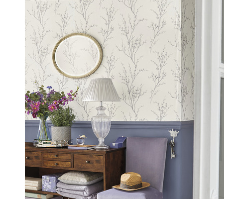 Dekorativ inredning med mönstrad tapet, spegel och byrå