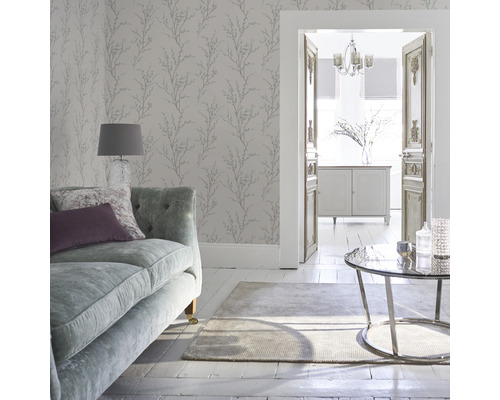 Vardagsrum med soffa, matta, bord och väggtapet med växtmönster