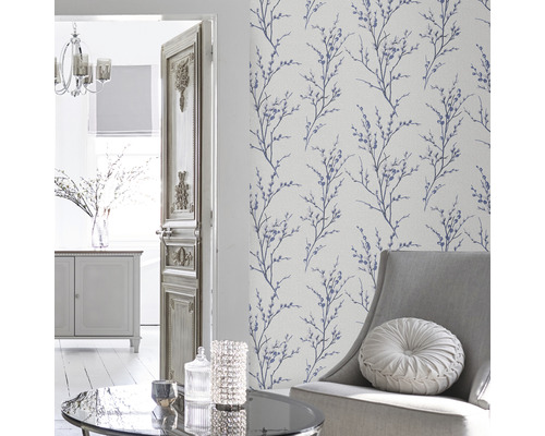 Vardagsrum med blommönstrad tapet, fåtölj och bord