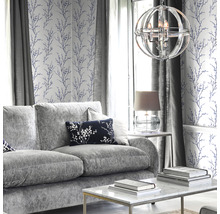 Vardagsrum med grå soffa, soffbord, lampa och tapet med blommönster