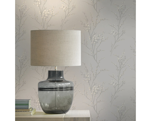 Scen med bordslampa och blommönstrad tapet