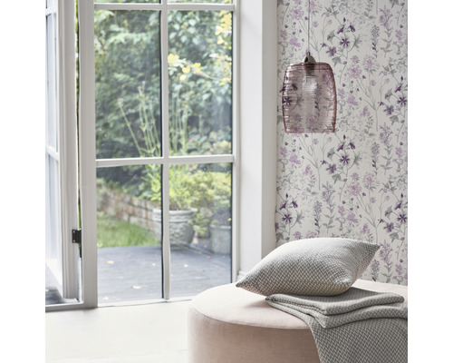 Dekorativ inredning med blommig tapet, fönster, lampa och kuddar