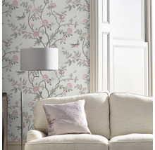 Vardagsrum med blommig tapet, soffa och golvlampa