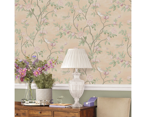 Dekorativ inredning med blommig tapet, bordslampa och blomsterarrangemang