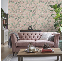 Vardagsrum med blommig tapet, soffa och dekorationer för en mysig atmosfär