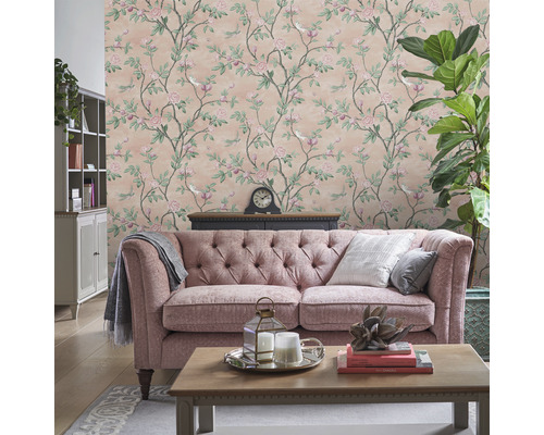 Vardagsrum med blommig tapet, soffa och dekorationer för en mysig atmosfär