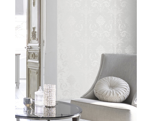 Ljus interiör med mönstrad tapet, fåtölj och bord