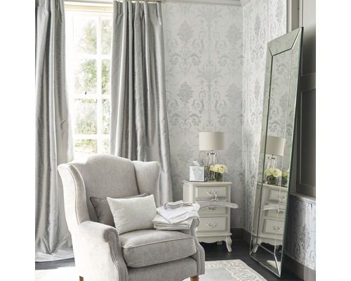 Elegant vardagsrum med fåtölj, gardiner, tapet, spegel och sängbord