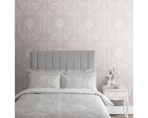 Sovrum med mönstrad tapet, säng och nattduksbord