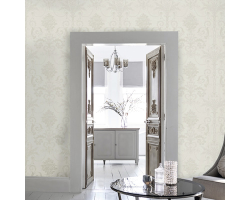 Ljust vardagsrum med blommig tapet och utsikt genom en öppen dörr.