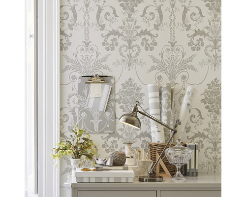 Dekorativt skrivbord med blommig tapet, skrivbordslampa och kontorsmaterial