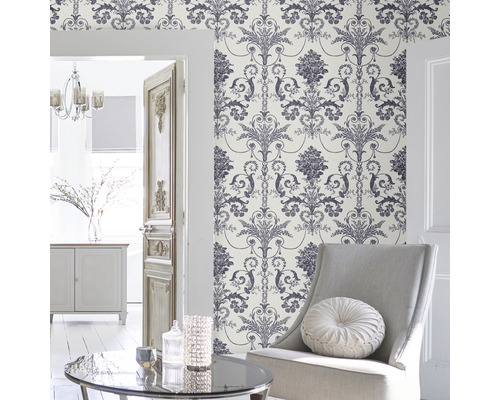 Scen av ett vardagsrum med blommigt tapetmönster, fåtölj och dekoration