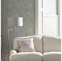 Miljöbild med tapet med fågel- och blomstermotiv, soffa och golvlampa