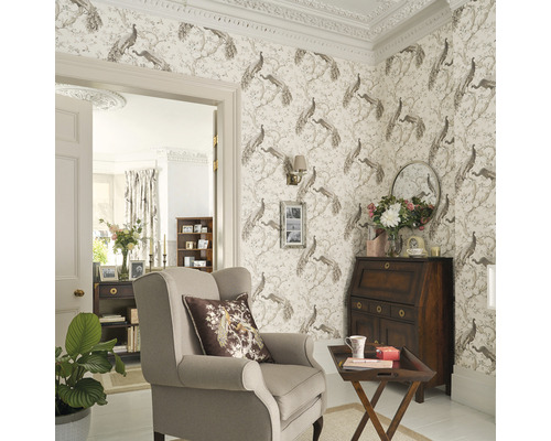 Dekorativt vardagsrum med tapeter, fåtölj och skrivbordssekretär