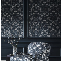 Dekorativ tapet med blommönster och matchande fåtölj i ett rum