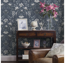 Dekorativt vardagsrum med blommig tapet, träkonsol och läderfåtölj