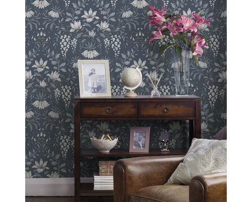 Dekorativt vardagsrum med blommig tapet, träkonsol och läderfåtölj