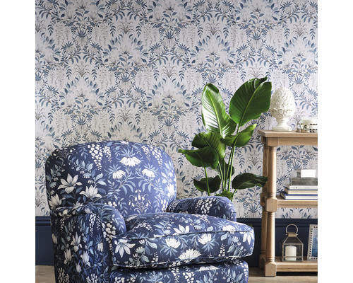 Dekorativt vardagsrum med mönstrad tapet, fåtölj och sidobord