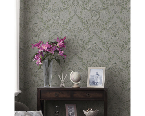 Rum med blommig tapet, mörkt träskåp, blommor och dekorationsföremål