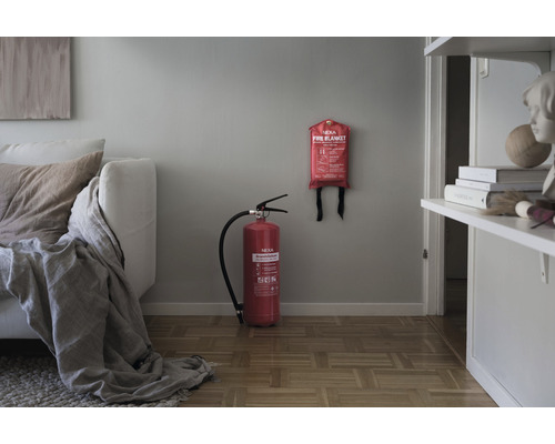 Vardagsrum med soffa, brandsläckare och brandfilt