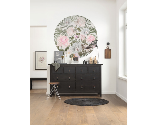 Inredningsidé med byrå, väggdekoration, pall och matta i ett ljust rum.