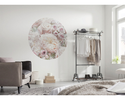 Vardagsrum med rund väggdekoration med blommönster, klädställning och fåtölj