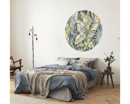 Sovrum med dubbelsäng, golvlampa och väggdekal med bladmotiv