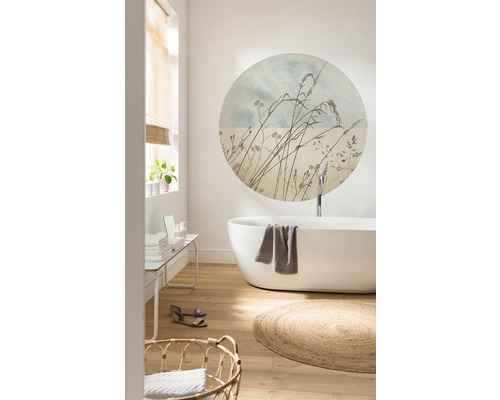 Ljust badrum med fristående badkar, rund väggdekal, trägolv och flätad matta