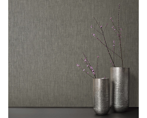 Närbild av en strukturtapet bredvid två vaser med blommande grenar.