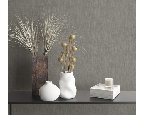 Dekorativa element på ett bord: Vasar, torkade blommor, bok och ljus.