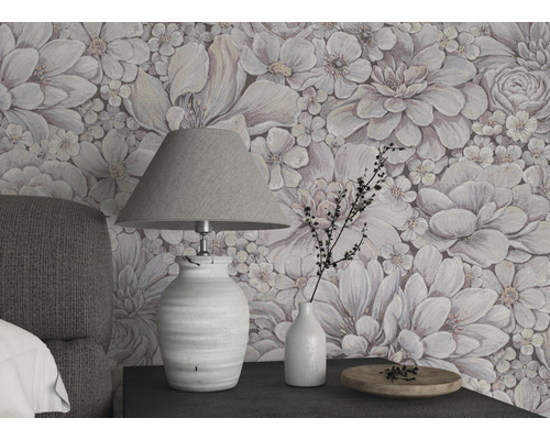 Vardagsrum med blomstertapet, bordslampa och dekorationer på ett nattduksbord