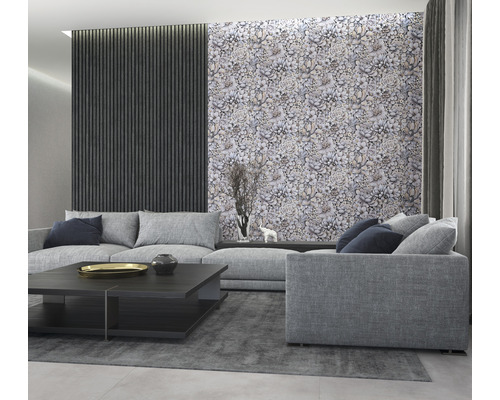 Vardagsrum med grå soffa, soffbord och en vägg med tapeter med växtmönster