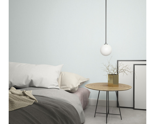 Sovrum med säng, sängbord, dekoration och hängande lampa