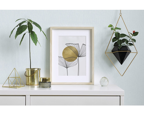 Dekorativ inredning med växt, bild och hängande planteringskärl på en byrå