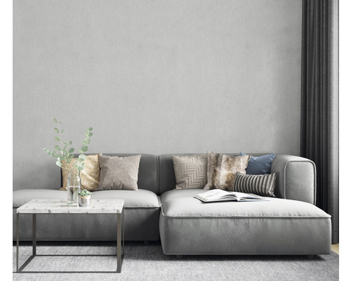 Vardagsrumsscen med grå hörnsoffa, kuddar, sidobord och dekoration