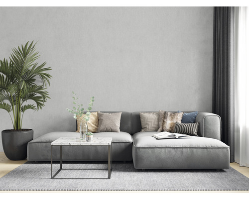 Vardagsrum i modern stil med grå soffa, kuddar, bord, krukväxt och matta