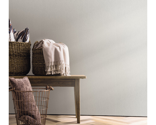 Dekorativ scen med korgar och textilier på ett träbord framför en vägg