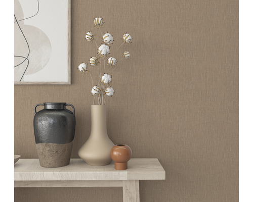 Dekorativa vaser och en tavla på ett bord framför en beige vägg